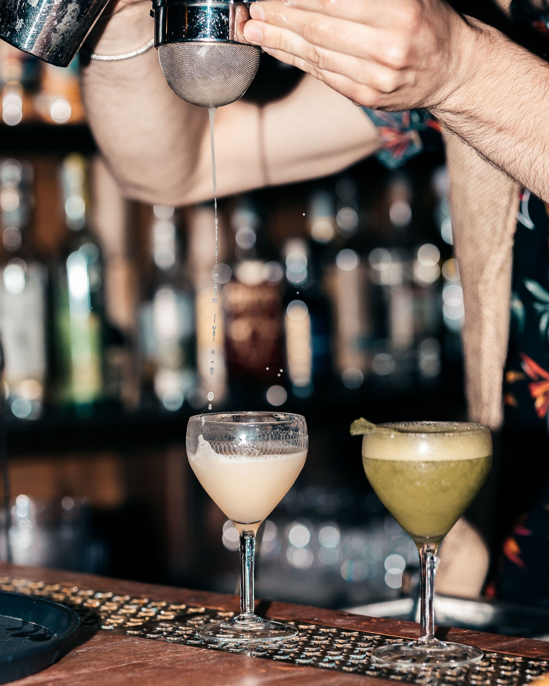 Mani di un bartender durante la preparazione di un cocktail